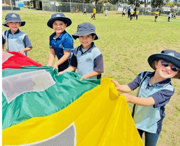 Photo of 4 students playing on the field.