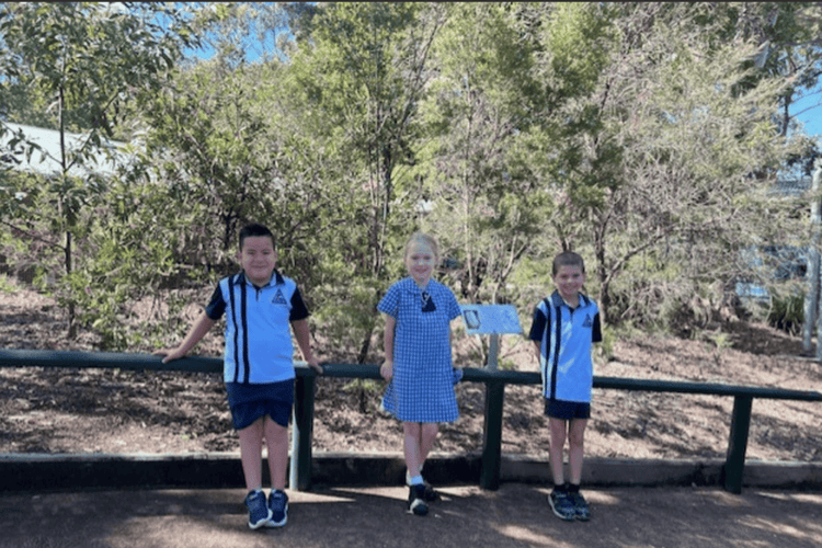 Three students standing in front of the cultural garden.