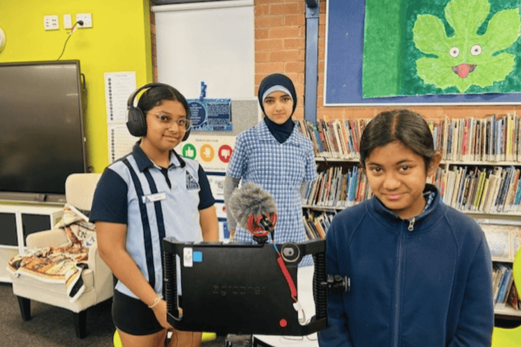 3 Students using the media technology to record a story.